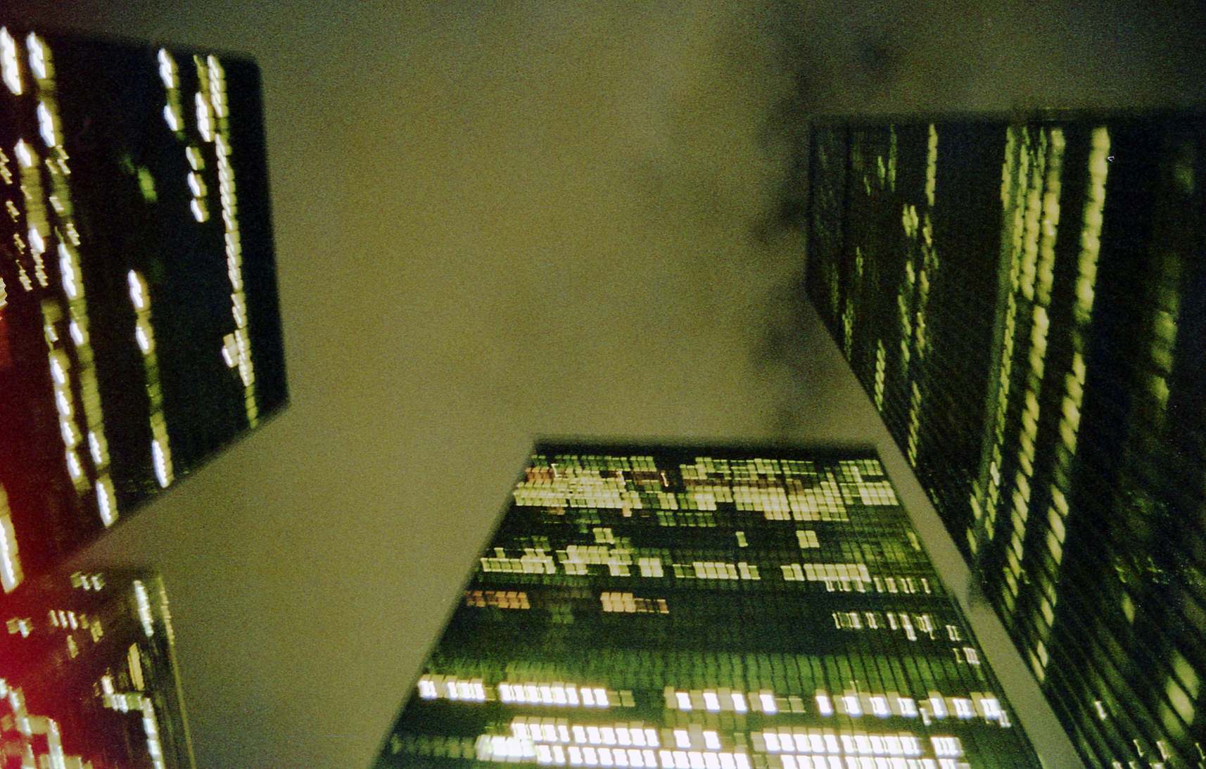 Night view of city buildings with office lights — skyscrapers under a cloudy night sky with city lights