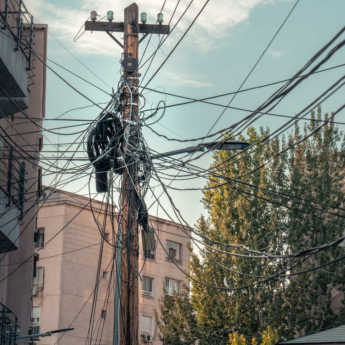 Close view of cabling and network hardware — messy web of power lines and cables, urban infrastructure